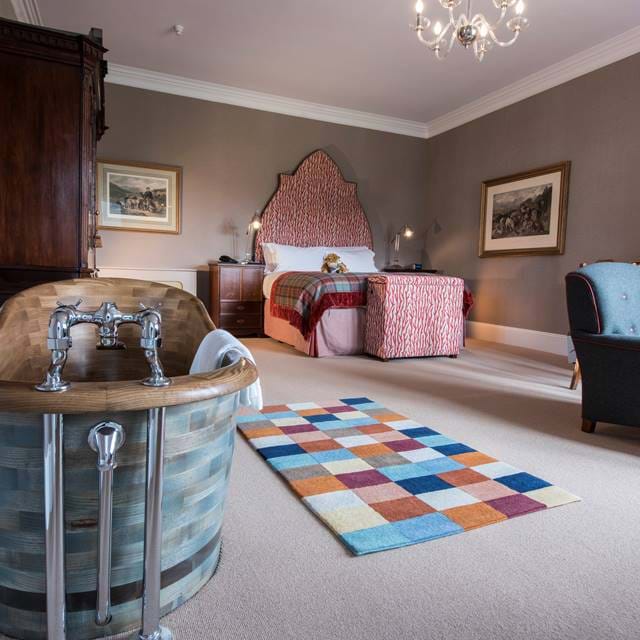 A view of a room with a freestanding bath and luxurious bedframe at The Torridon.
