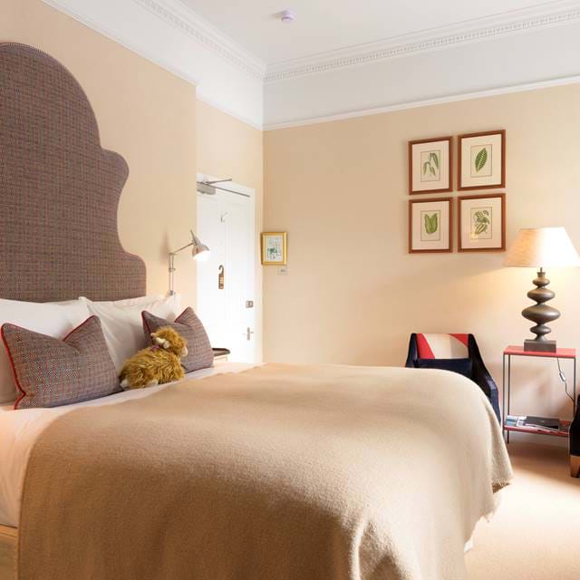 Elegantly furnished room at The Torridon featuring neutral tones and luxury bedding.