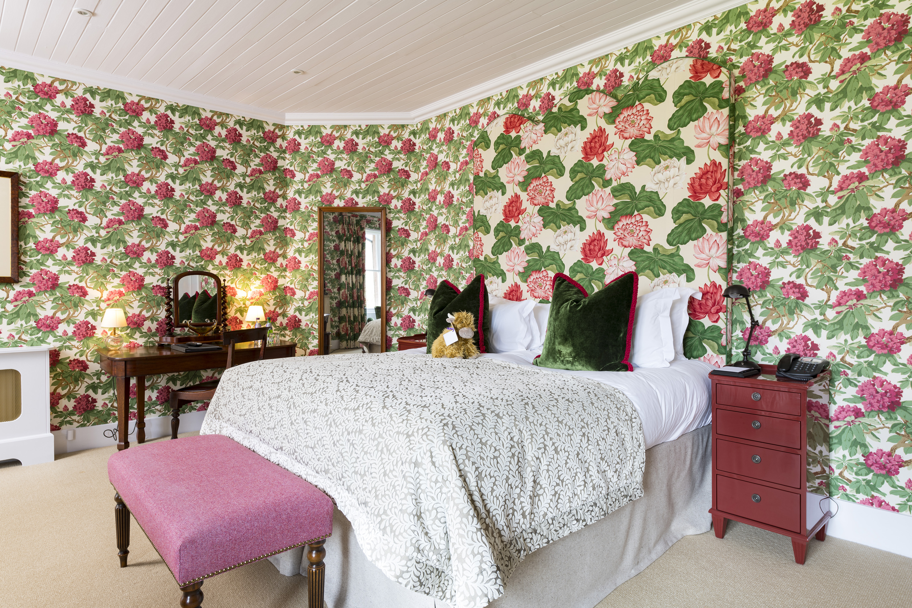 Bedroom at The Torridon featuring a large bed with soft linens and stylish floral decor.