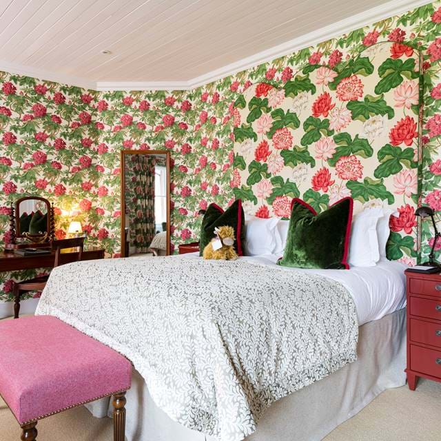 Bedroom at The Torridon featuring a large bed with soft linens and stylish floral decor.