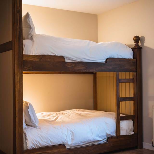 Elegant family room in The Torridon stables, offering a comfortable bunk bed and scenic views.